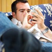 Man on couch looking at iPhone