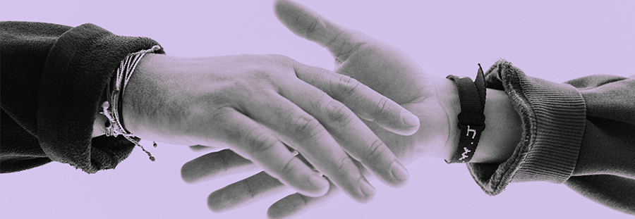 Two hands reaching out to hold each other. Purple overlay over the image with a blank background. 