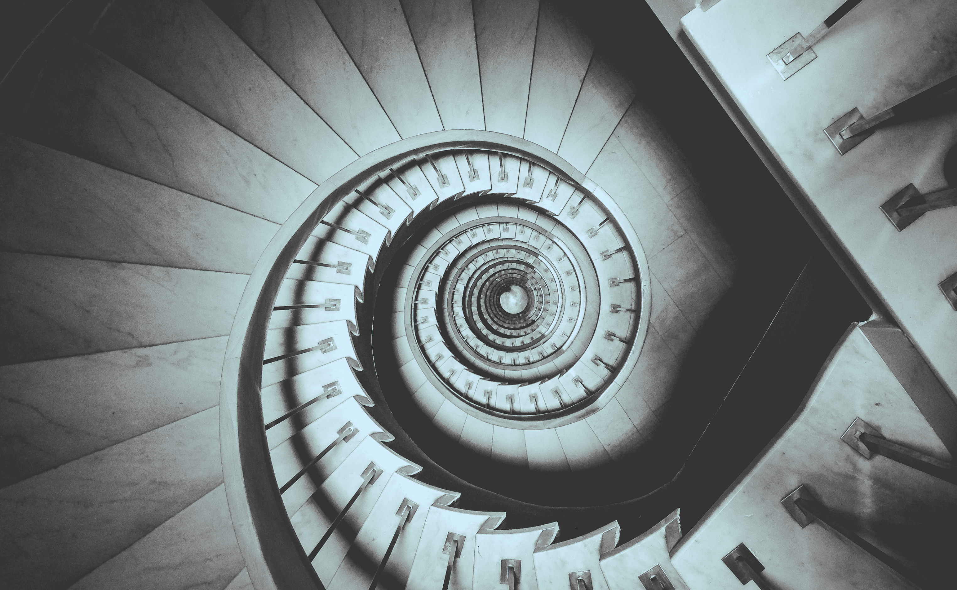 Staircase top view that appears like a swirl with a washed out blue hue overlay
