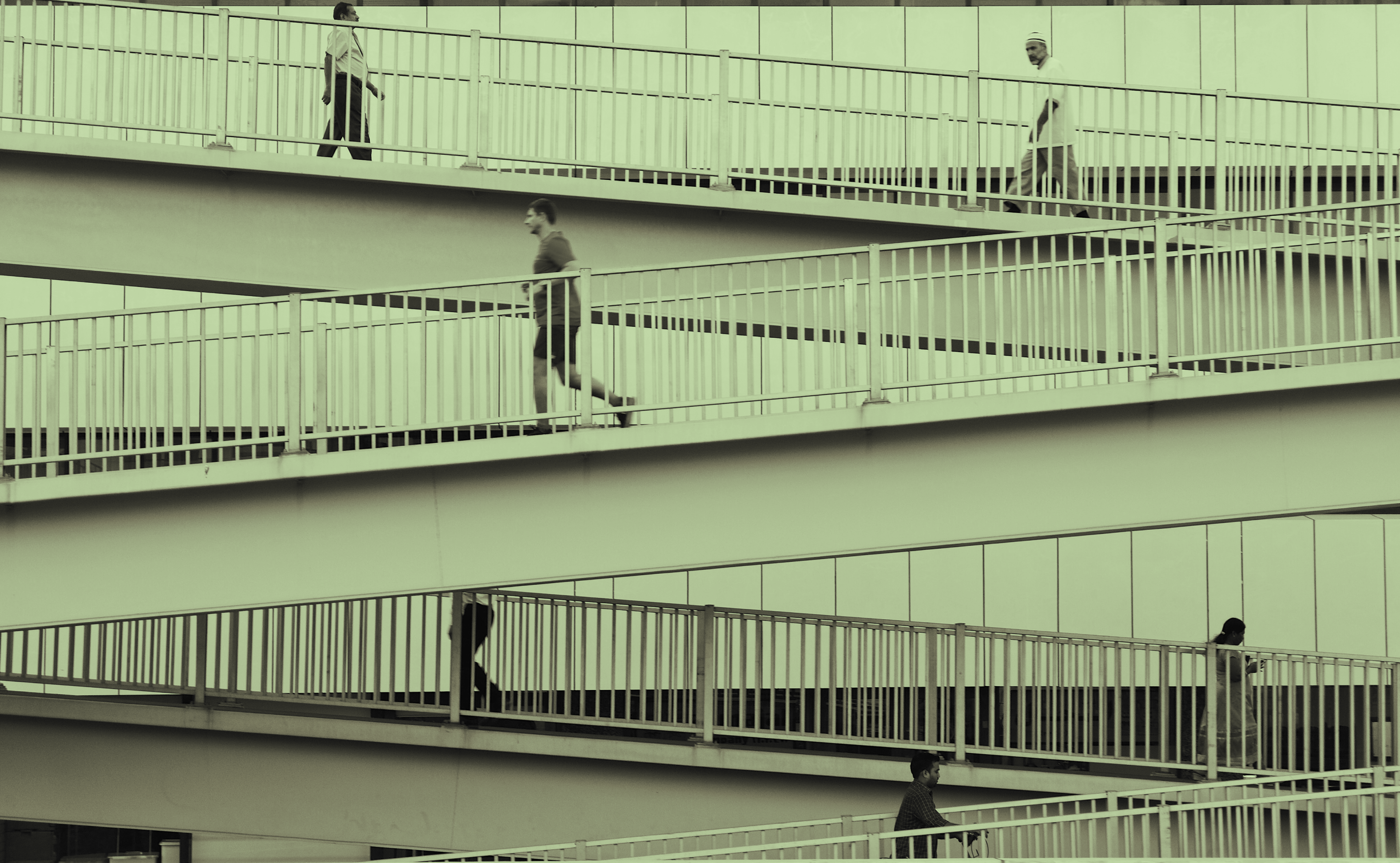 Three straight staircases with four people walking and running on them with a yellow hue overlaying the image.
