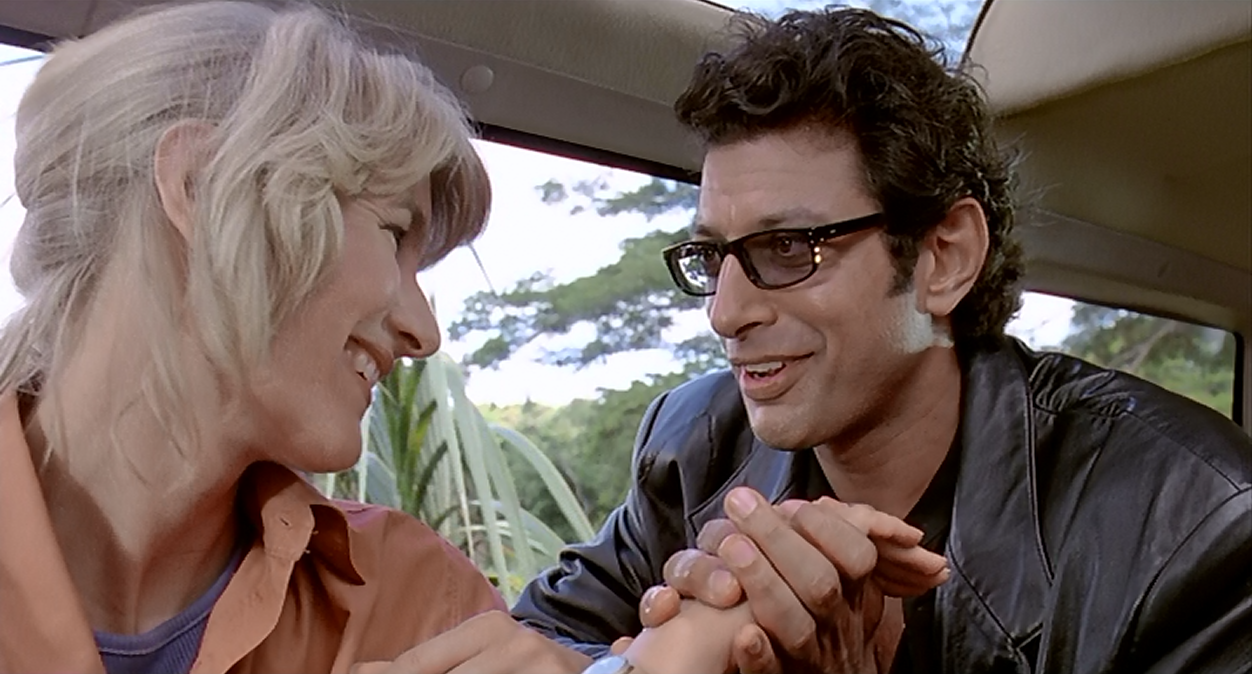 Jeff Goldblum's character holds Laura Dern's hands and smiles reassuringly