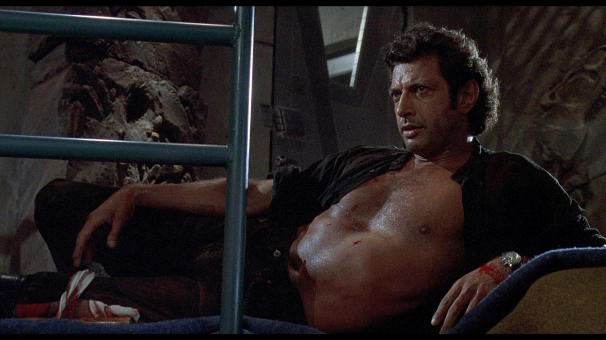 Jeff Goldblum reclines with his shirt unbuttoned and his sweaty chest exposed
