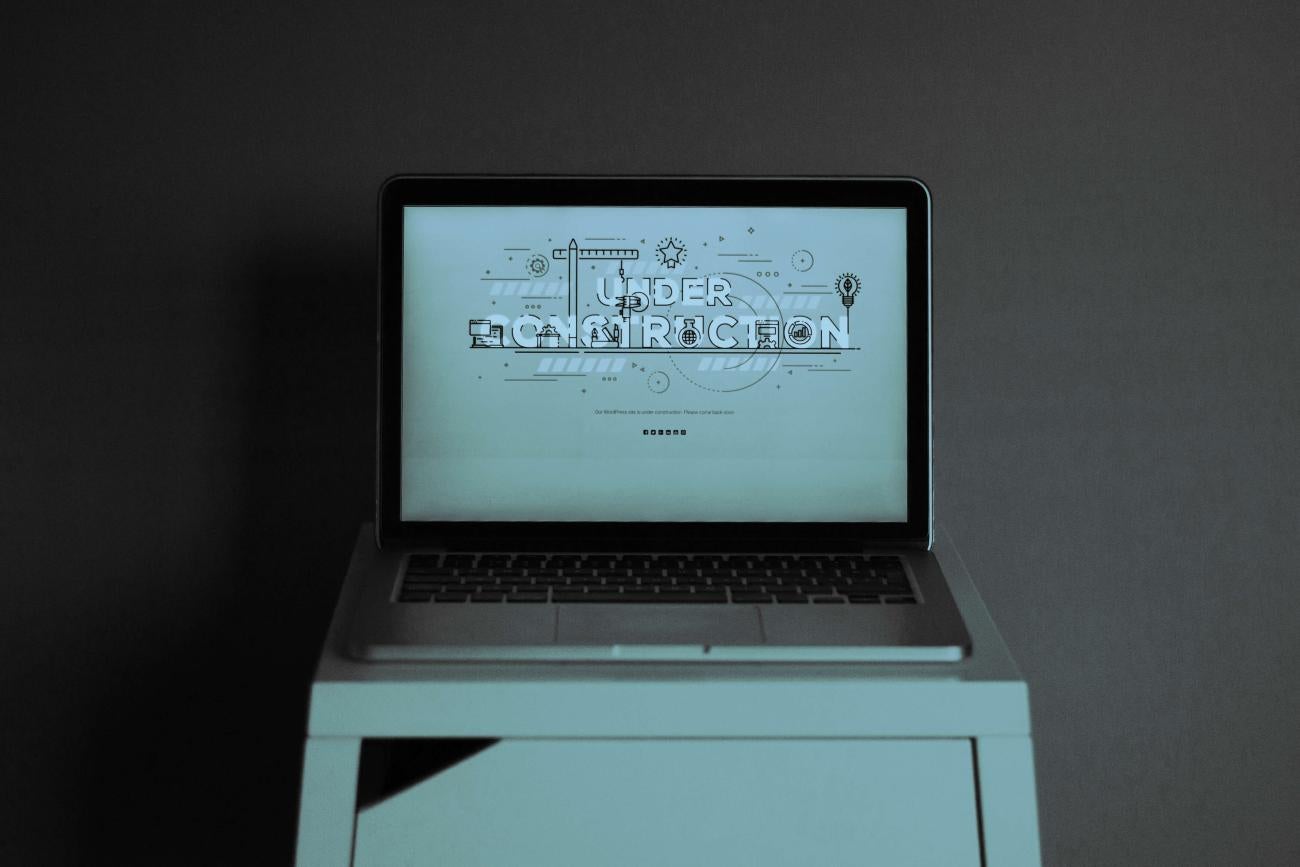  A computer showing a screen that reads "under construction" implying that a website is being built.
