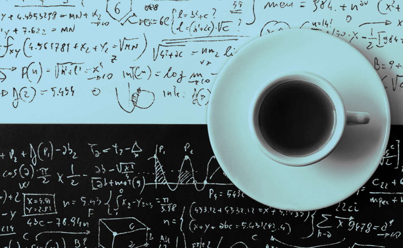 An image of a coffee cup sitting on a table that has mathematical formulas written into it. 