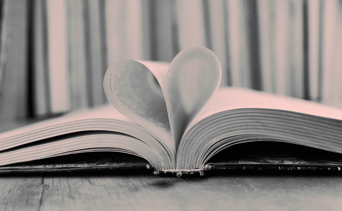 Image of a book with two pages folded into the binding, making a heart shape. 